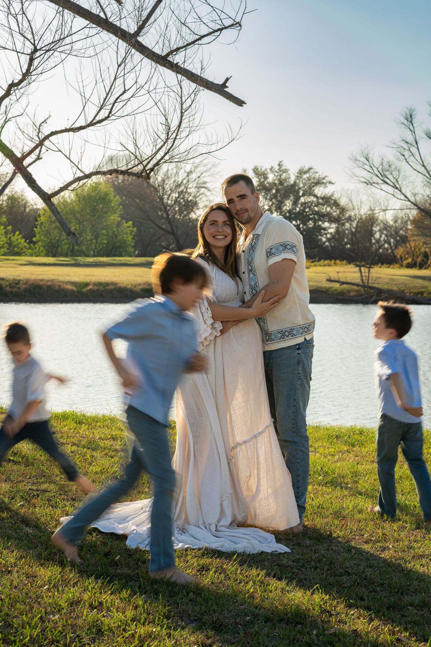 A sequence of playful motion photos showing a family enjoying time together by a lake at sunset.