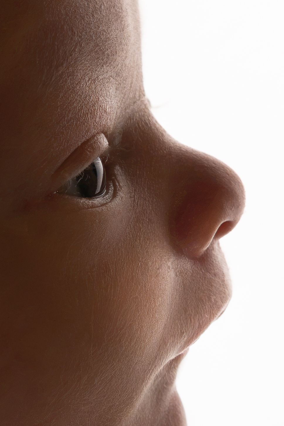 Close-up side profile of a person's face highlighting the eye and nose in dramatic lighting.