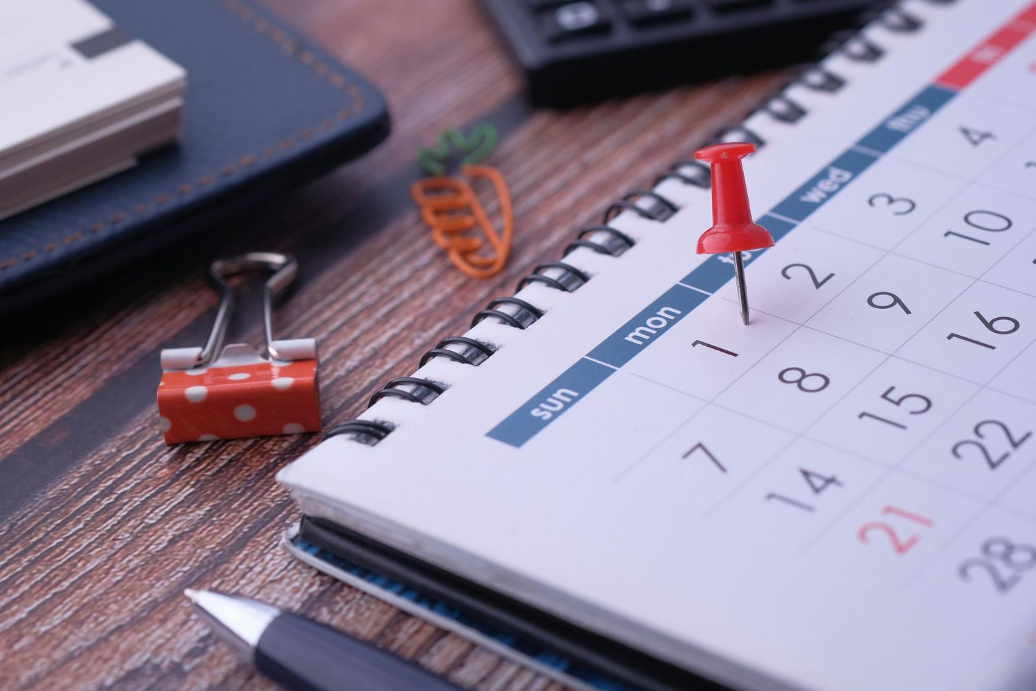 Calendar pages flipping across multiple images showing dates and numbers on wooden desk surface.
