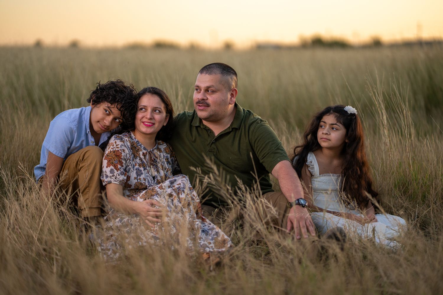 Family relaxing together in golden evening light.