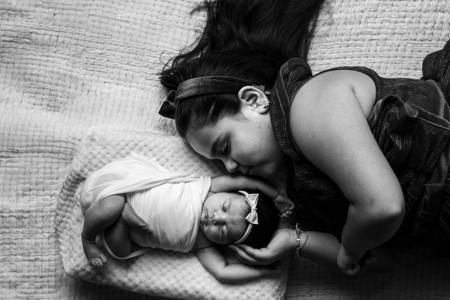 A series of black and white photographs showing a sleeping figure curled up in bed.