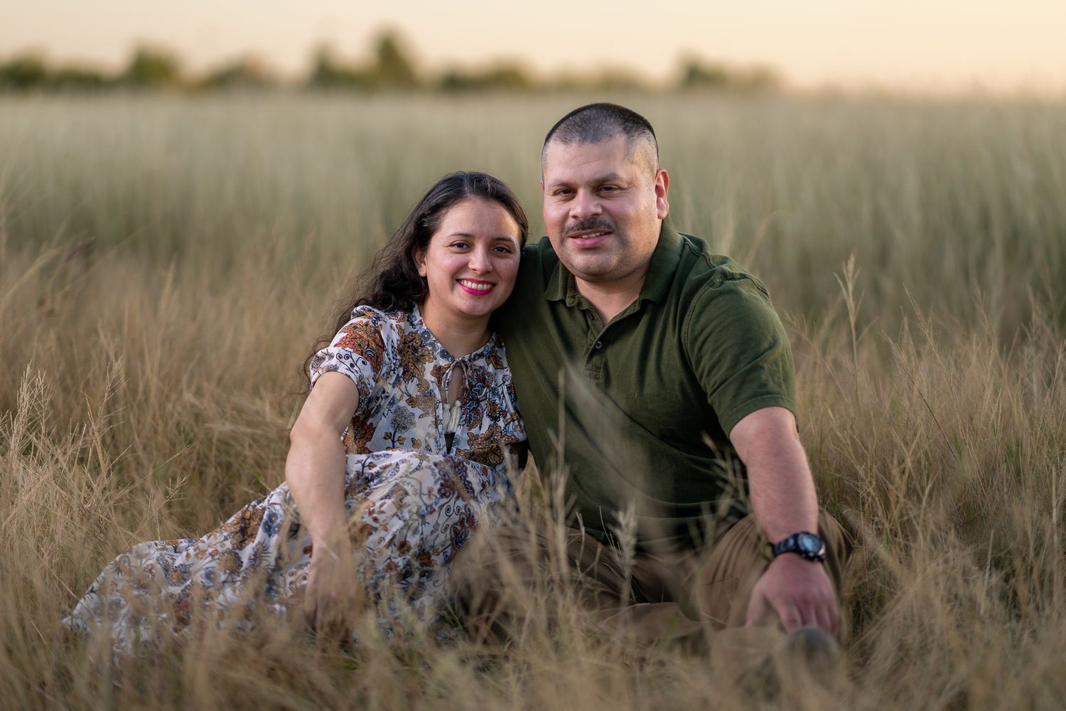 Intimate family portrait session in a rustic field at dusk.