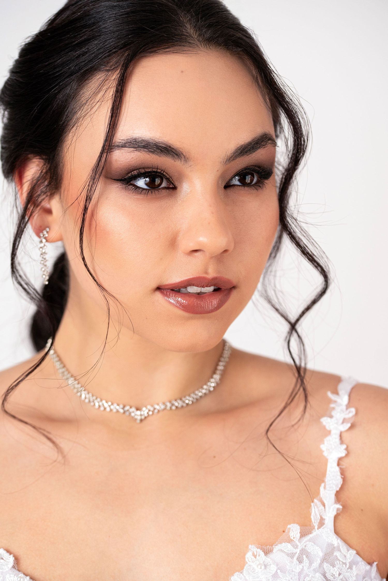 Sophisticated bridal portrait featuring crystal necklace and romantic makeup.