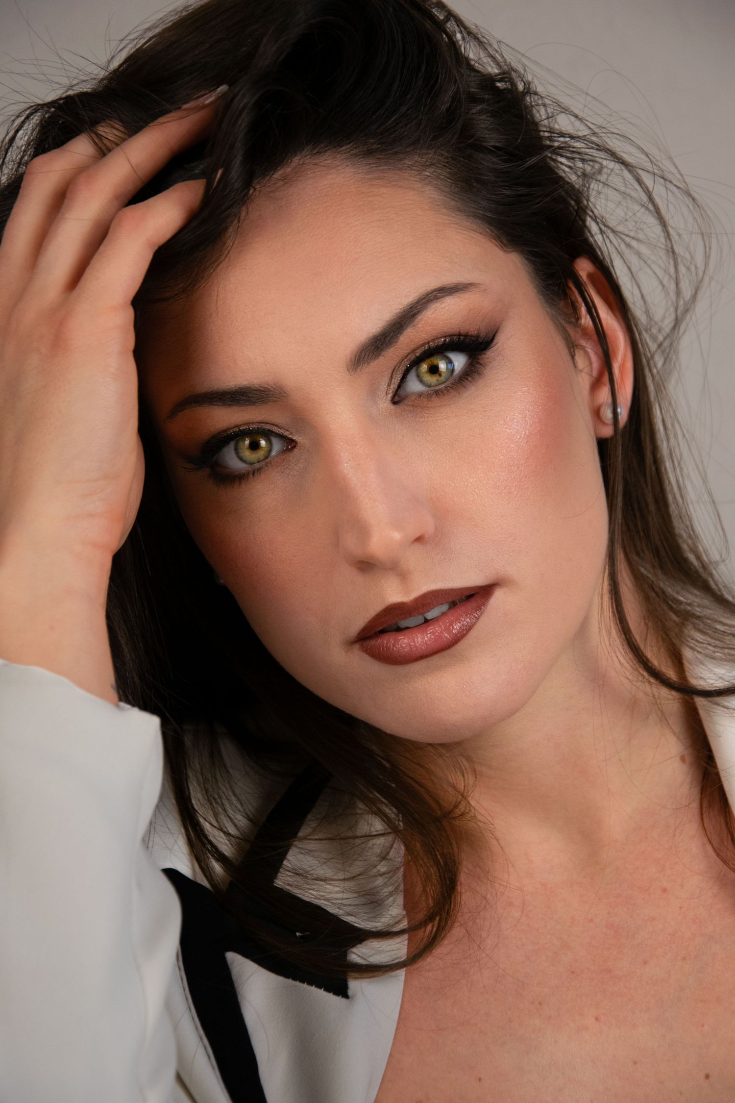 A series of close-up beauty portraits featuring dramatic lighting, dark hair, and striking eye makeup.