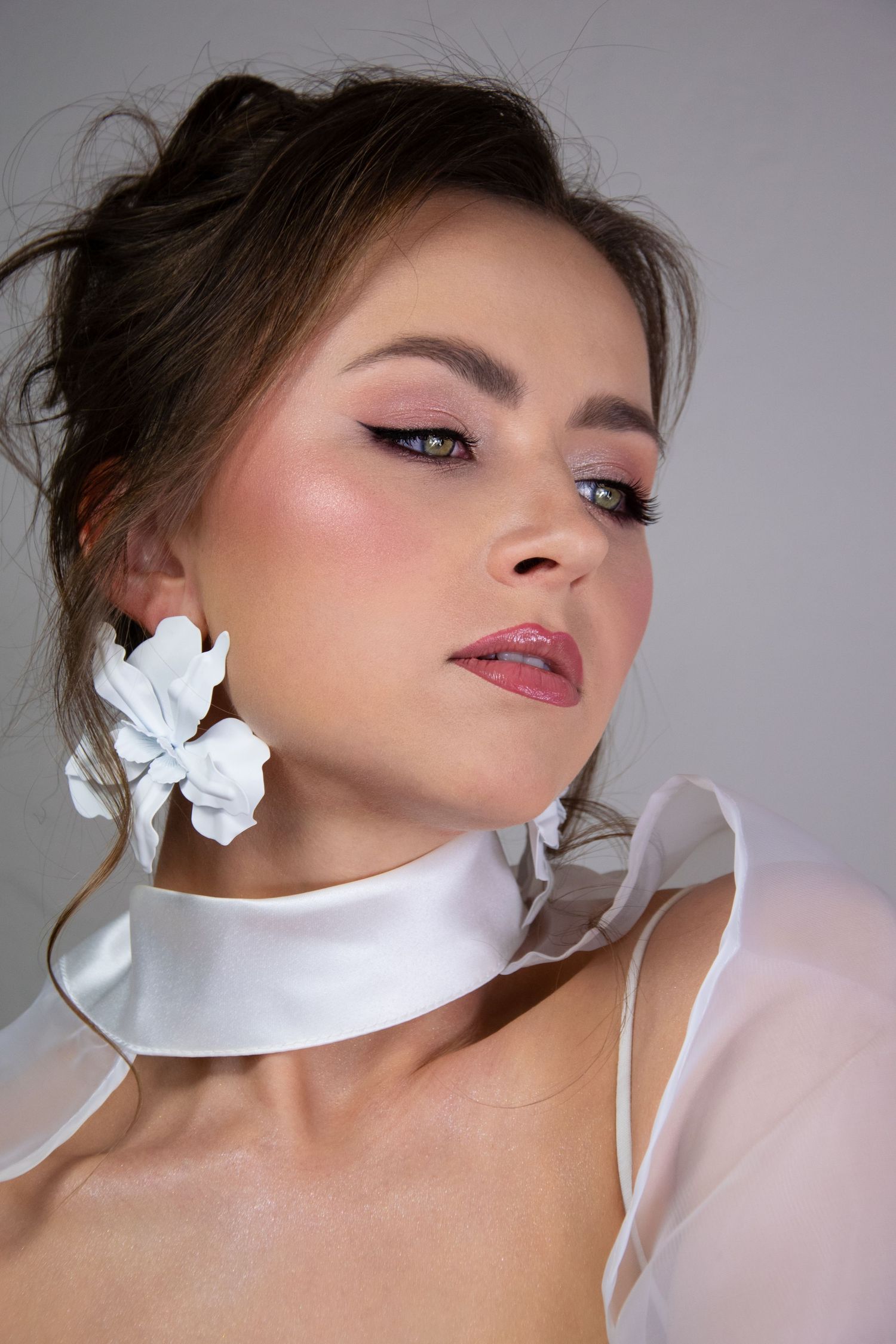 Fashion beauty portrait with white floral accessories and elegant satin choker in soft lighting.