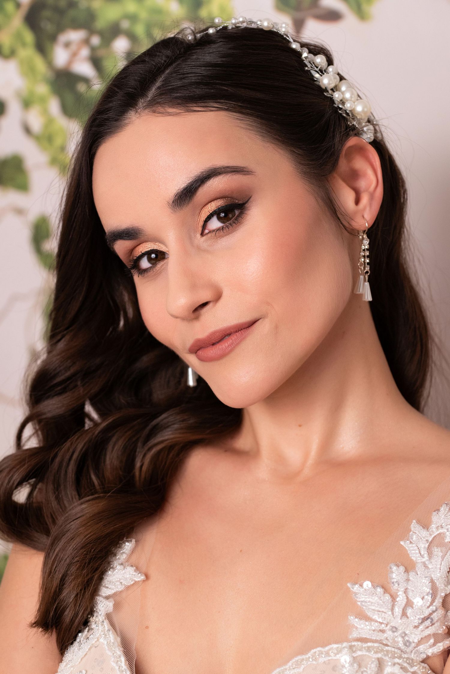 Bridal beauty portrait with pearl headpiece, lace gown and soft glam makeup.