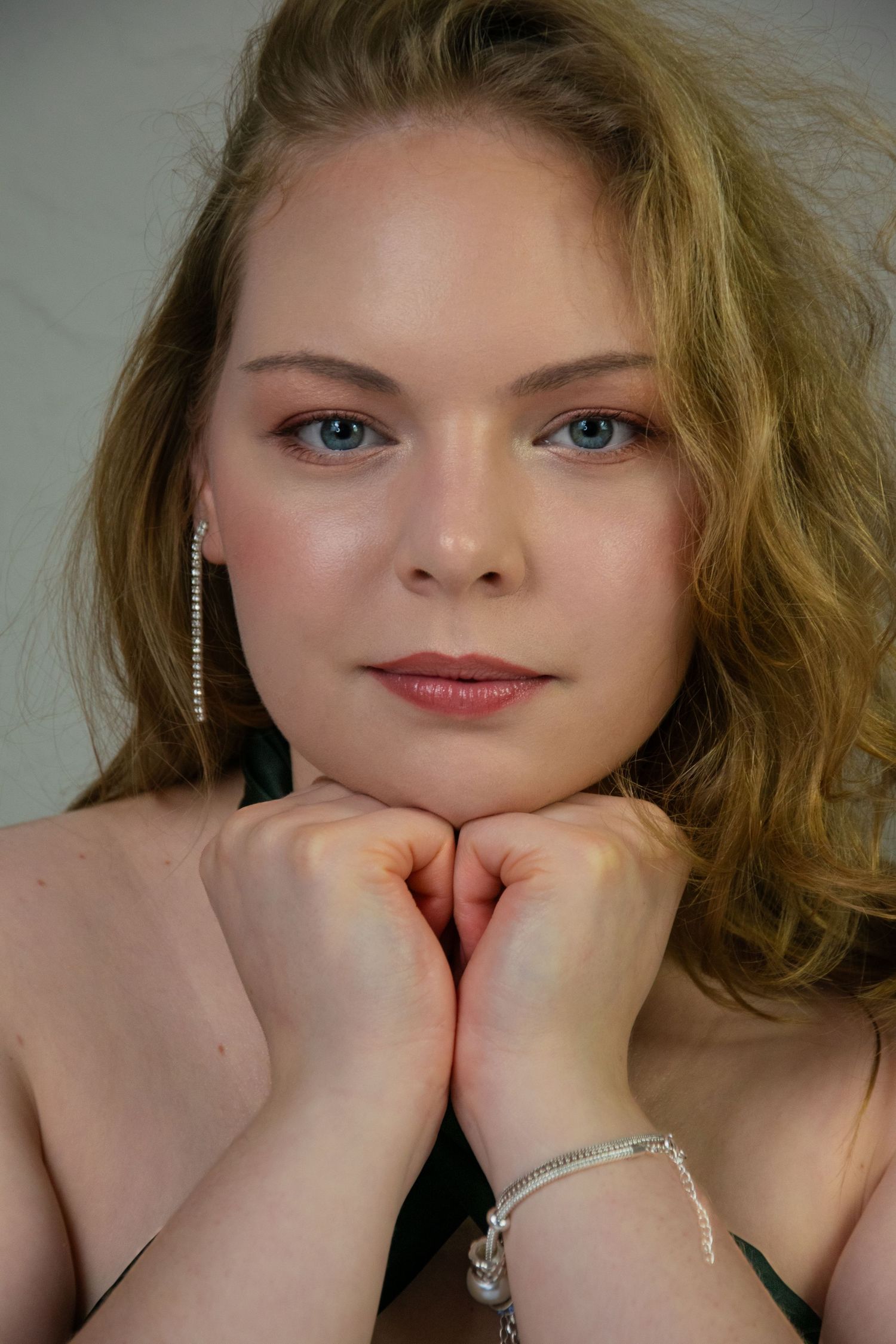 A series of close-up portraits showing blonde hair and expressive poses with hands near the face.