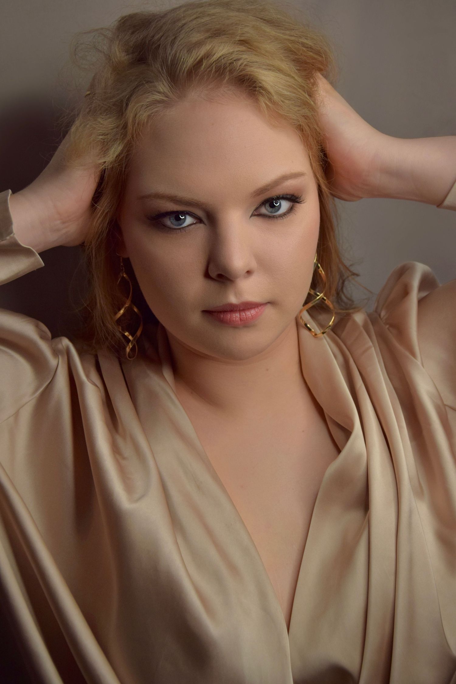 Dramatic portrait in champagne silk robe with sophisticated evening makeup.