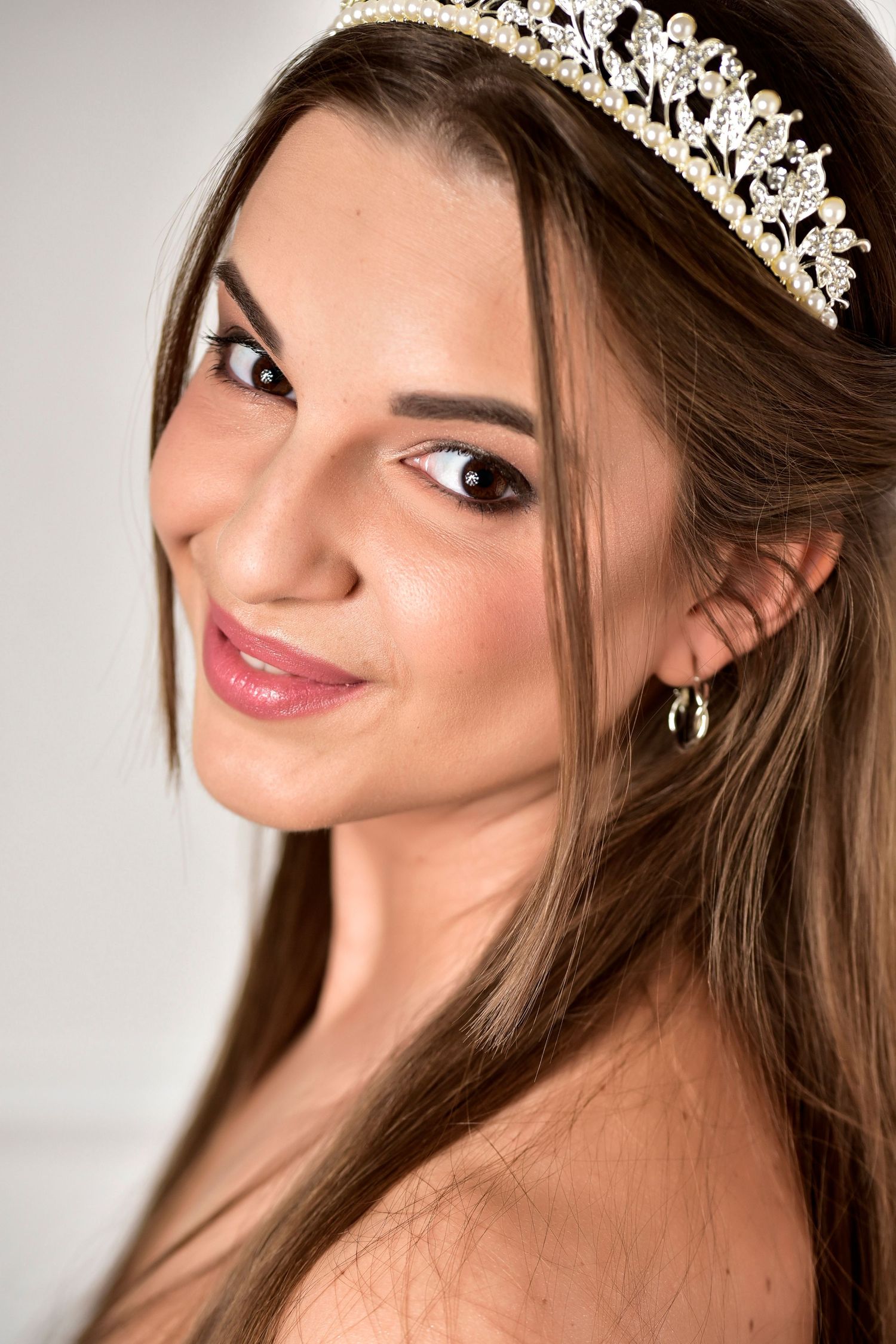 Elegant bridal portrait with a delicate crystal tiara and natural makeup look.