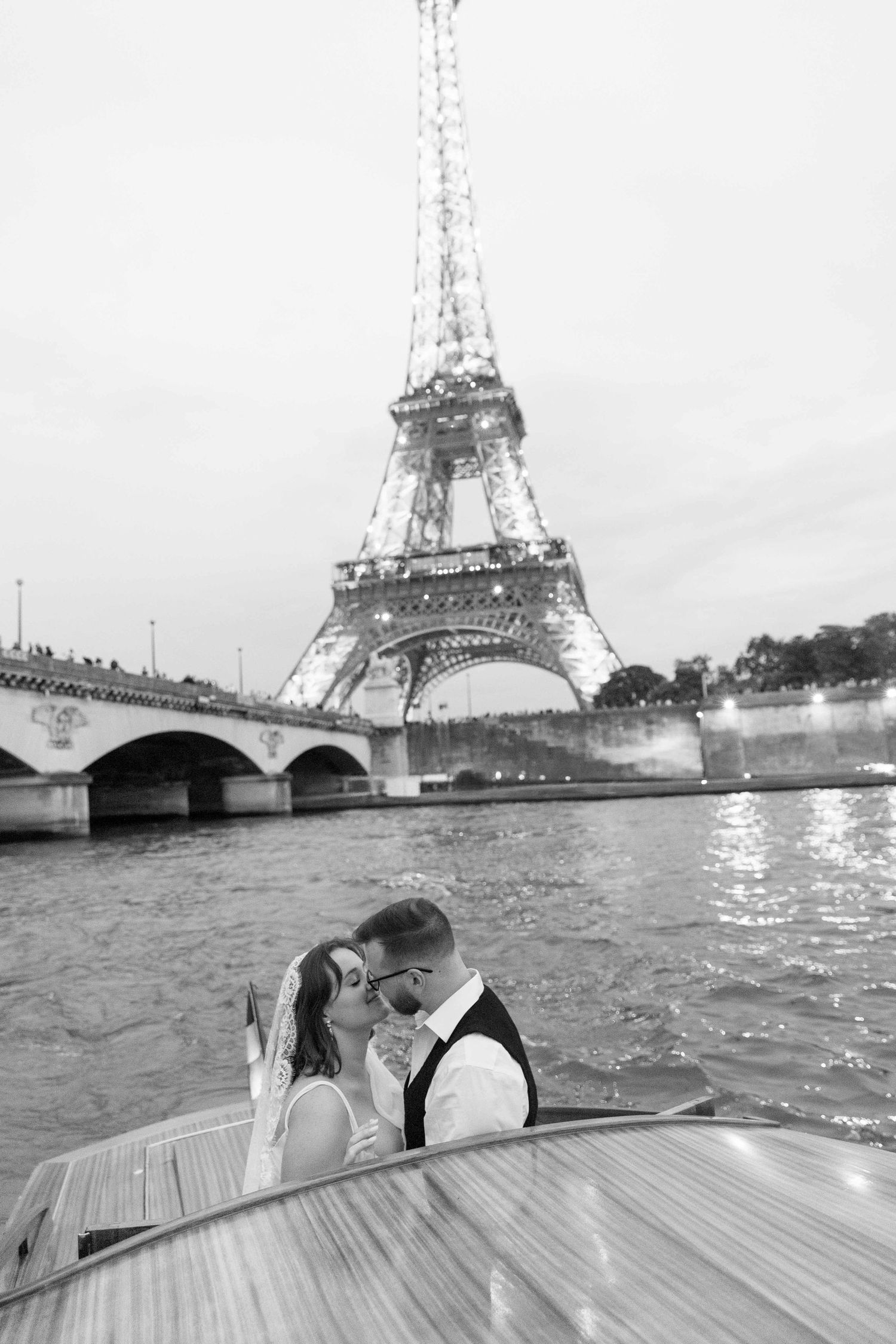 Couple kissing on a boat on the Seine River with the illuminated Eiffel Tower in the background, Paris.