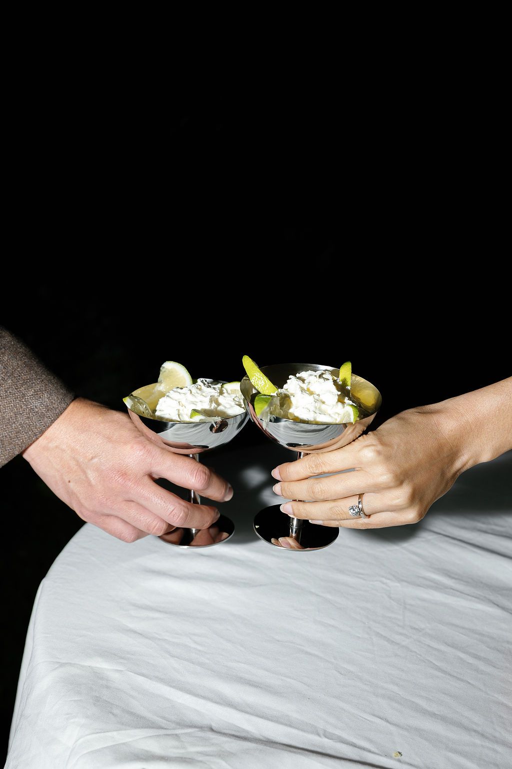 Close-up sequence of hands exchanging pieces of wedding cake across a white tablecloth in Tuscany, Italy.
