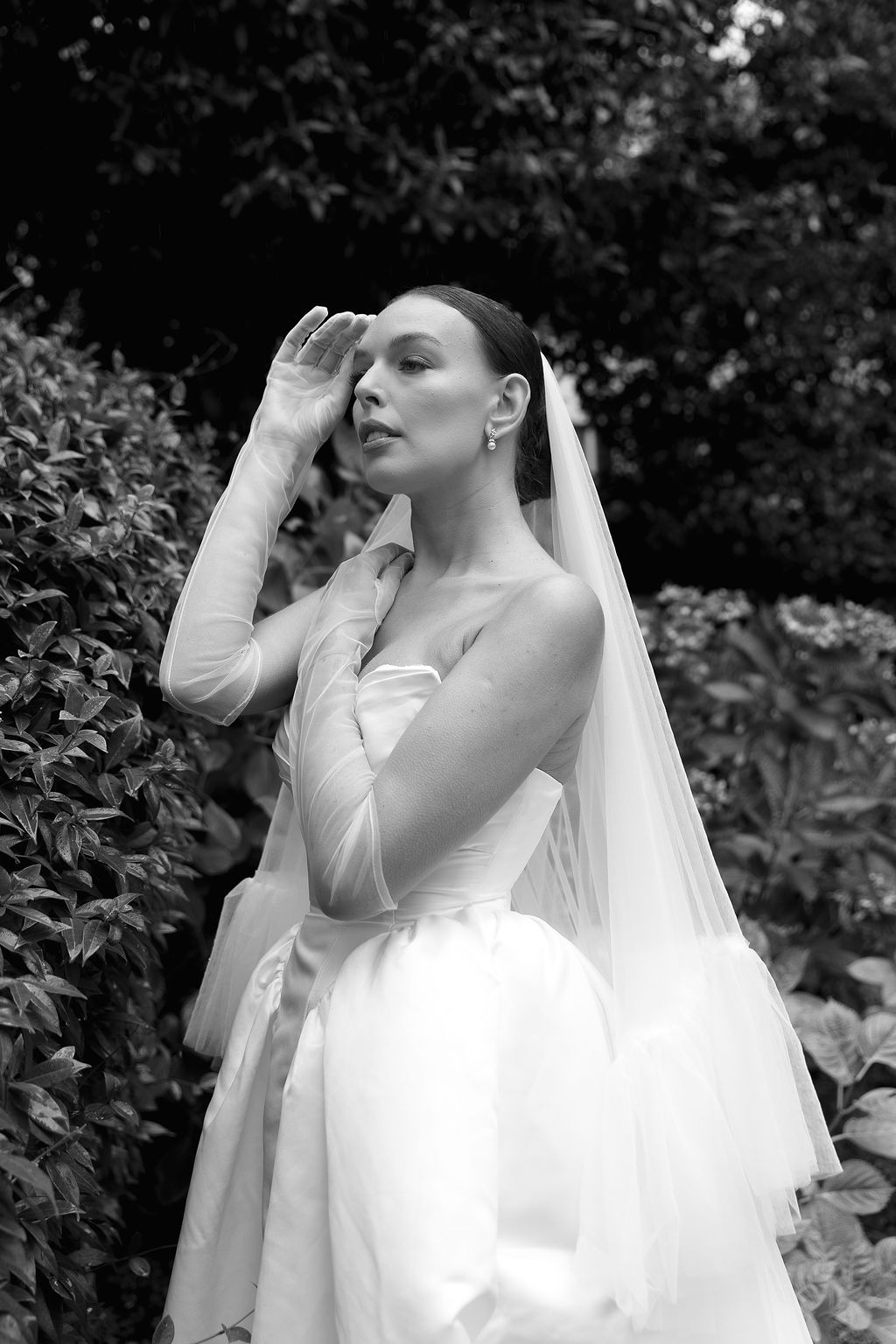 Dramatic black and white close-up shots of a bride with flowing veil against natural foliage in Lake Como.