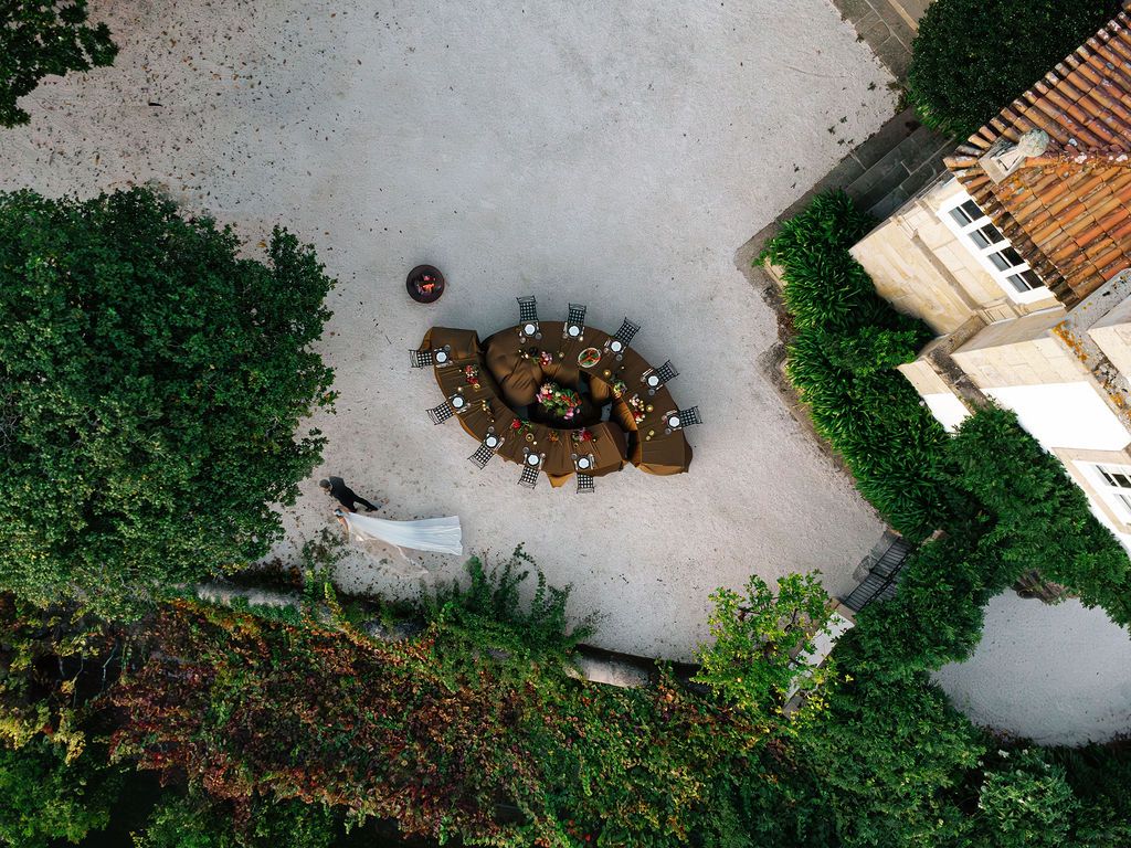 Aerial view of a large group of cyclists riding together in formation on a winding road through green landscape in Portugal.