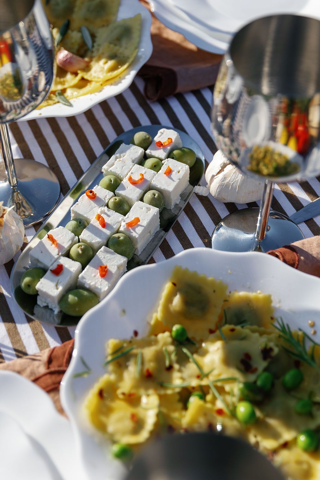 Elegant wedding reception table setting with appetizers and decorative white boxes on striped tablecloth in Tuscany, Italy.