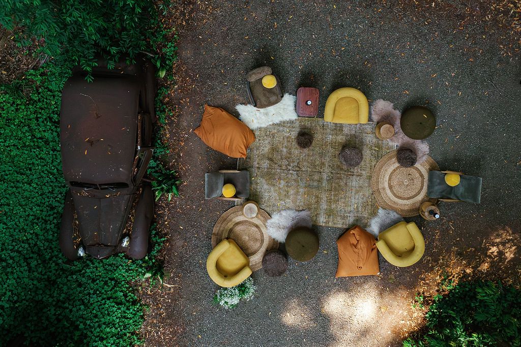 Aerial view of outdoor wedding reception tables with string lights at dusk.