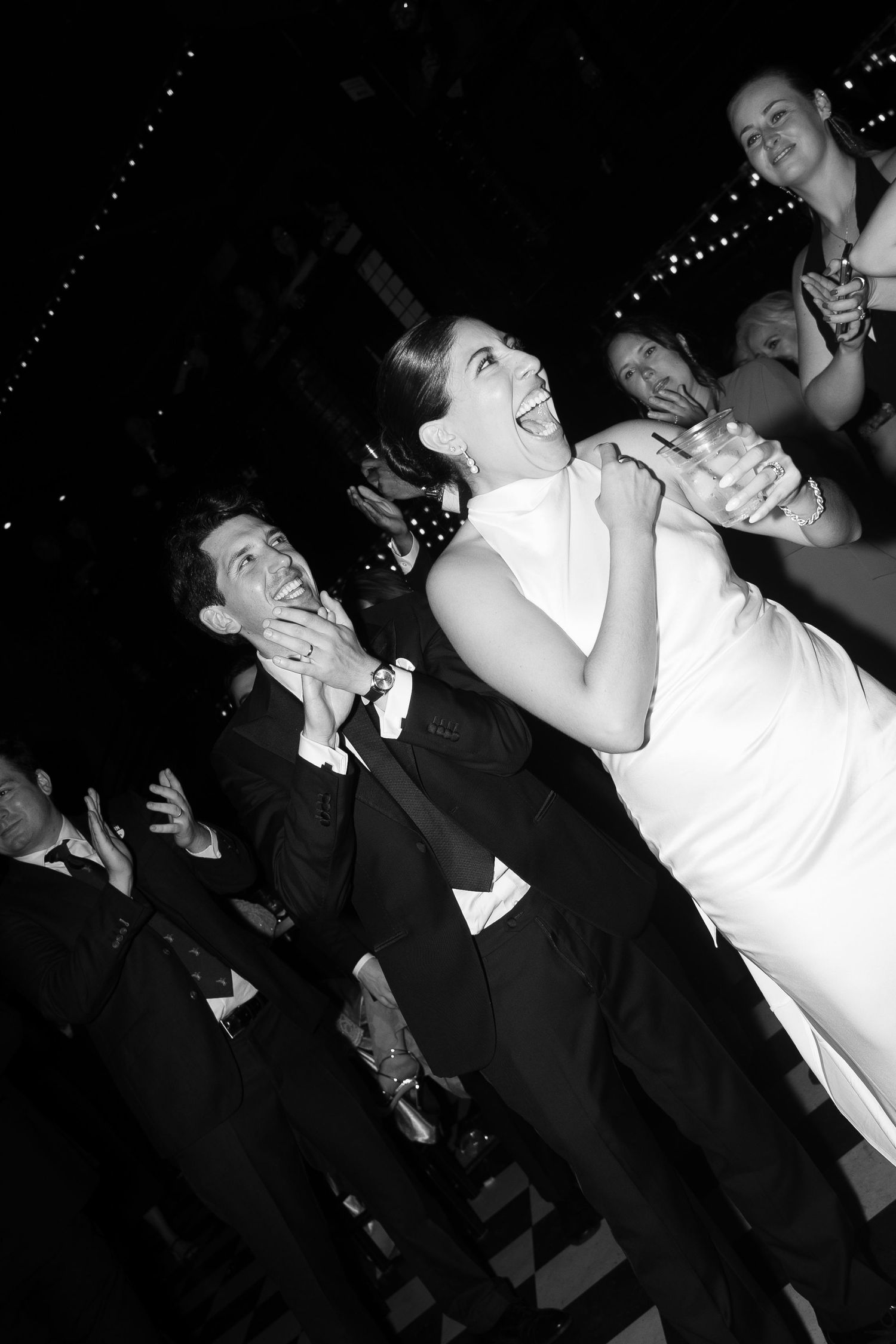 Black and white photo sequence showing two people dancing and laughing at what appears to be a party or celebration.