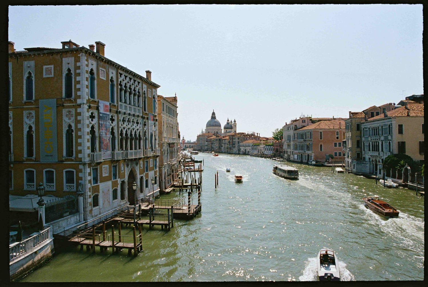 Scenic view of Venice Grand Canal with historic buildings, boats on water, and Santa Maria della Salute dome in background.