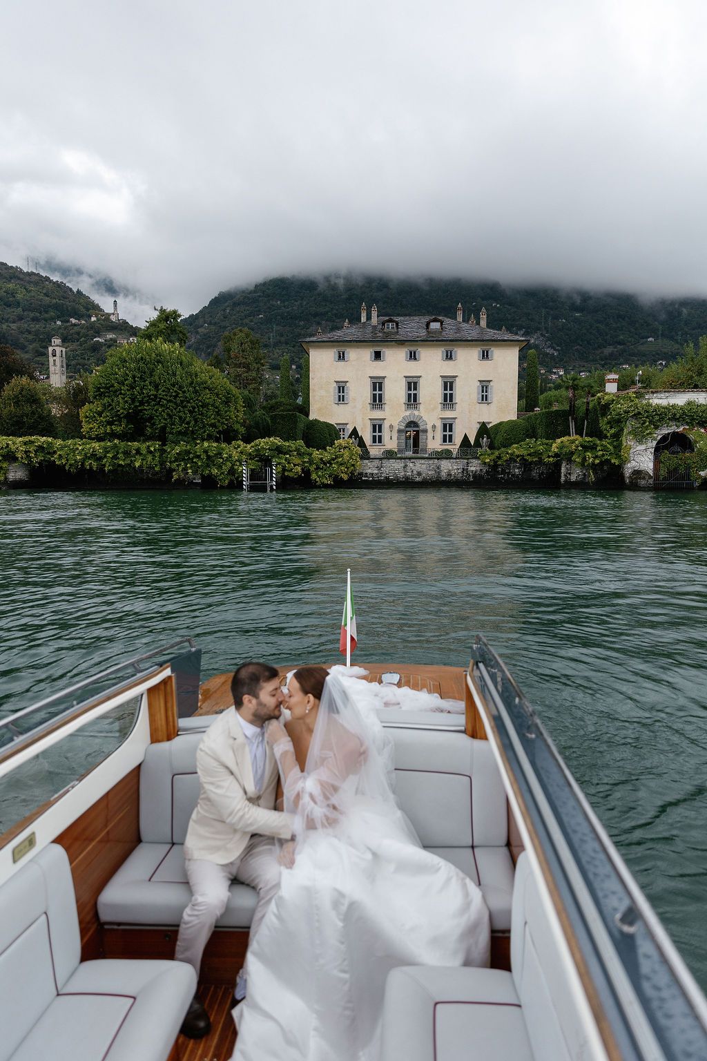 A romantic boat ride on Lake Como with elegant villas and misty mountains in the background.