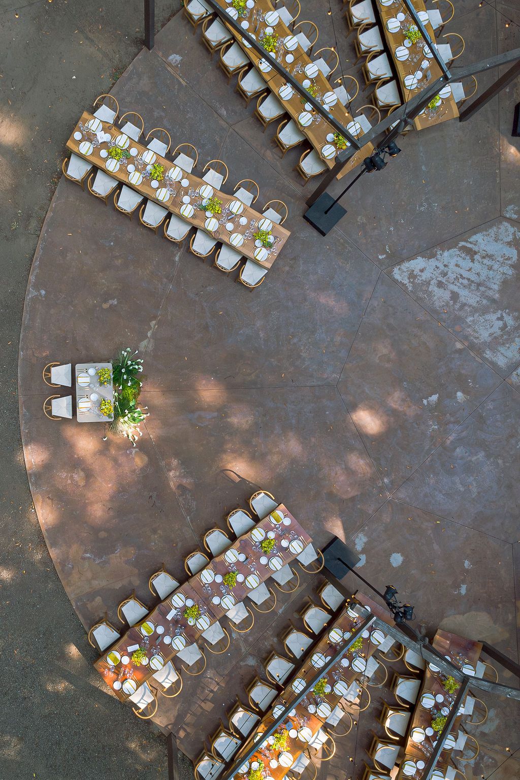Aerial view of white chairs arranged in rows on a concrete surface for an outdoor event.