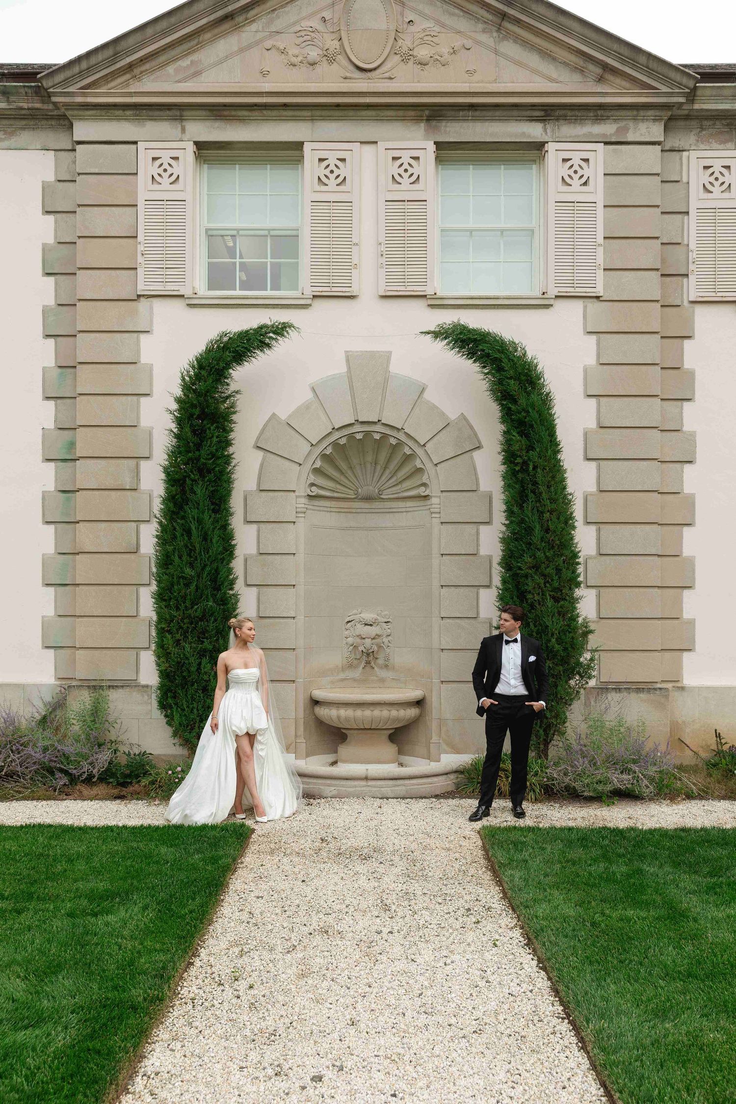 Wedding couple poses separately in a sequence of photos against an elegant stone building with arched alcoves and cypress trees.