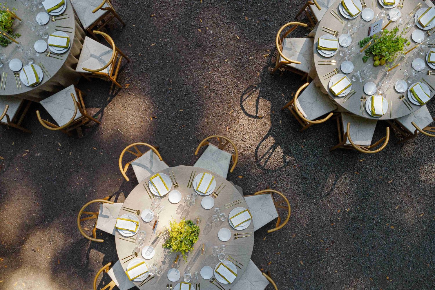 Overhead view of elegant round banquet tables with white linens and floral centerpieces at a formal event venue.