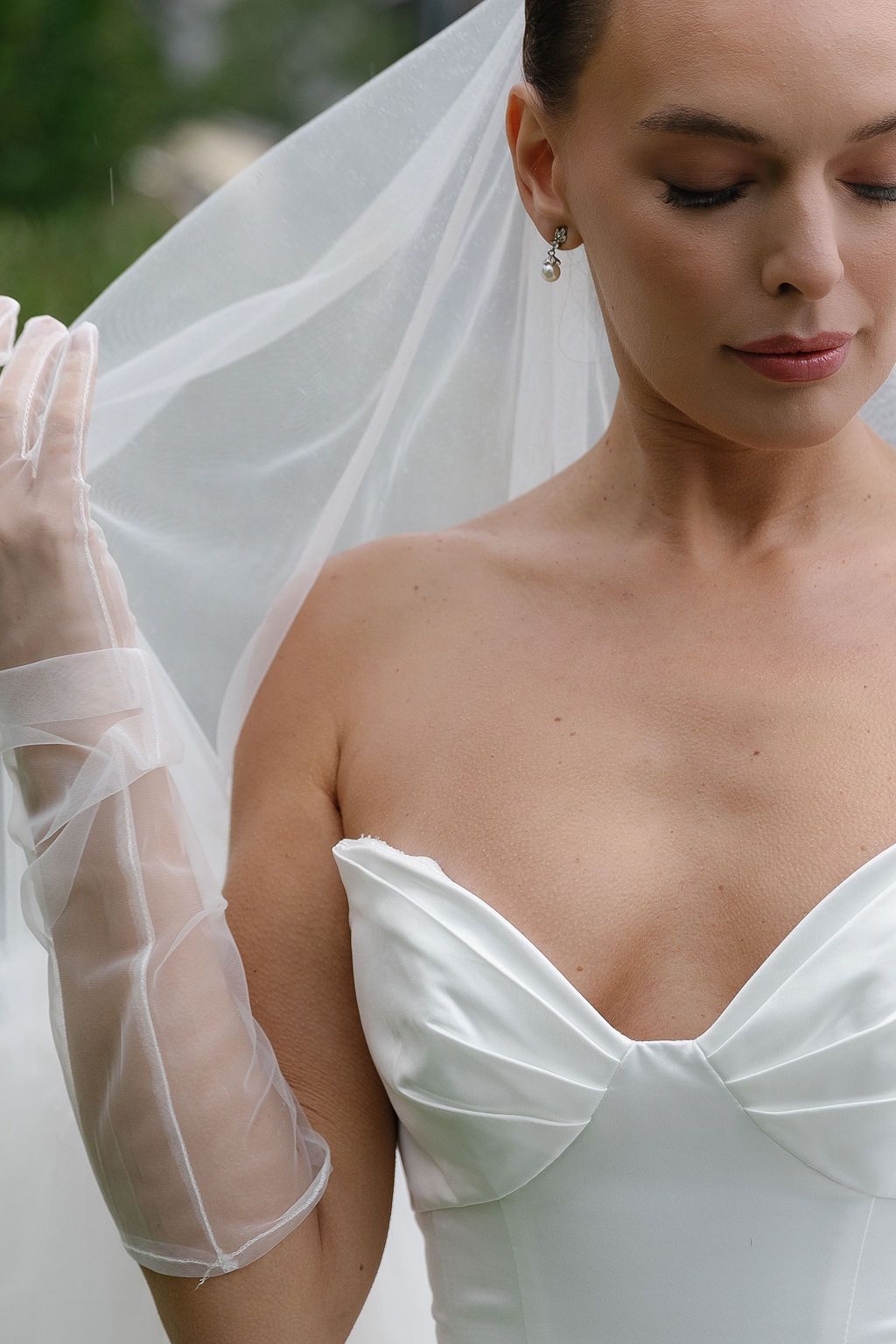 Close-up details of an couture elegant white wedding dress with delicate sheer fabric and structured sweetheart neckline in Lake Como.