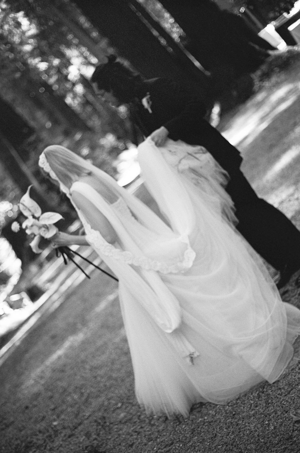 Black and white artistic photo of a flowing wedding dress moving in the breeze.