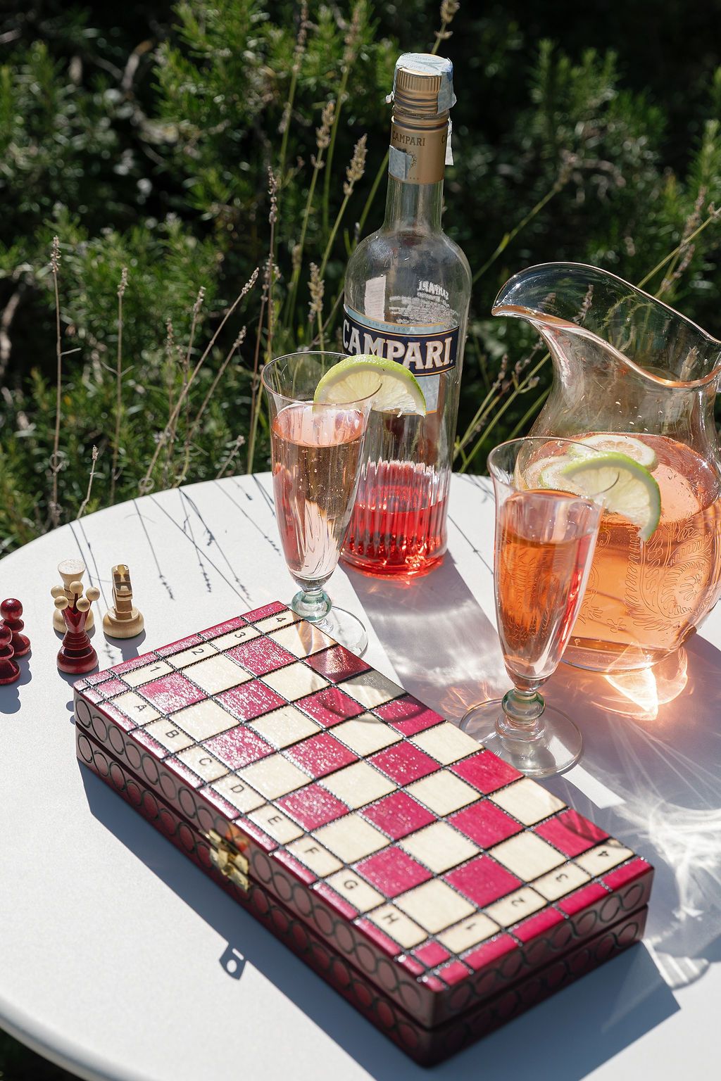 A pink and white checkered dessert display with cocktails and drinks on an outdoor table setting in Tuscany, Italy.