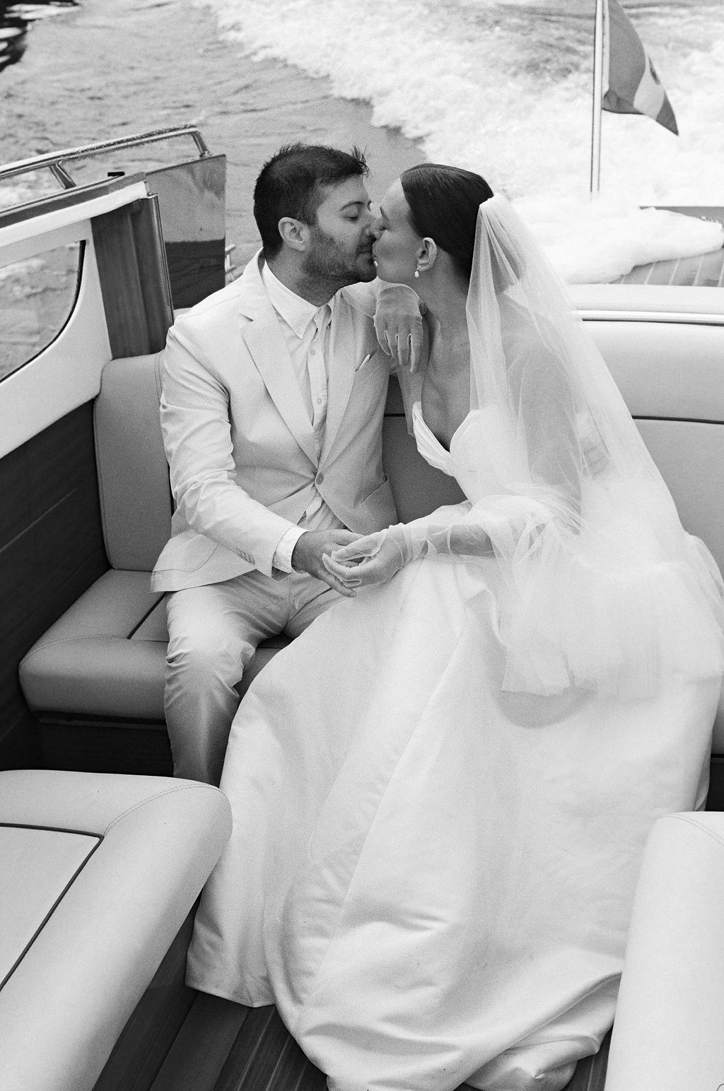 A series of romantic black and white wedding photos showing tender moments in the back of a Italian boat in Lake Como.