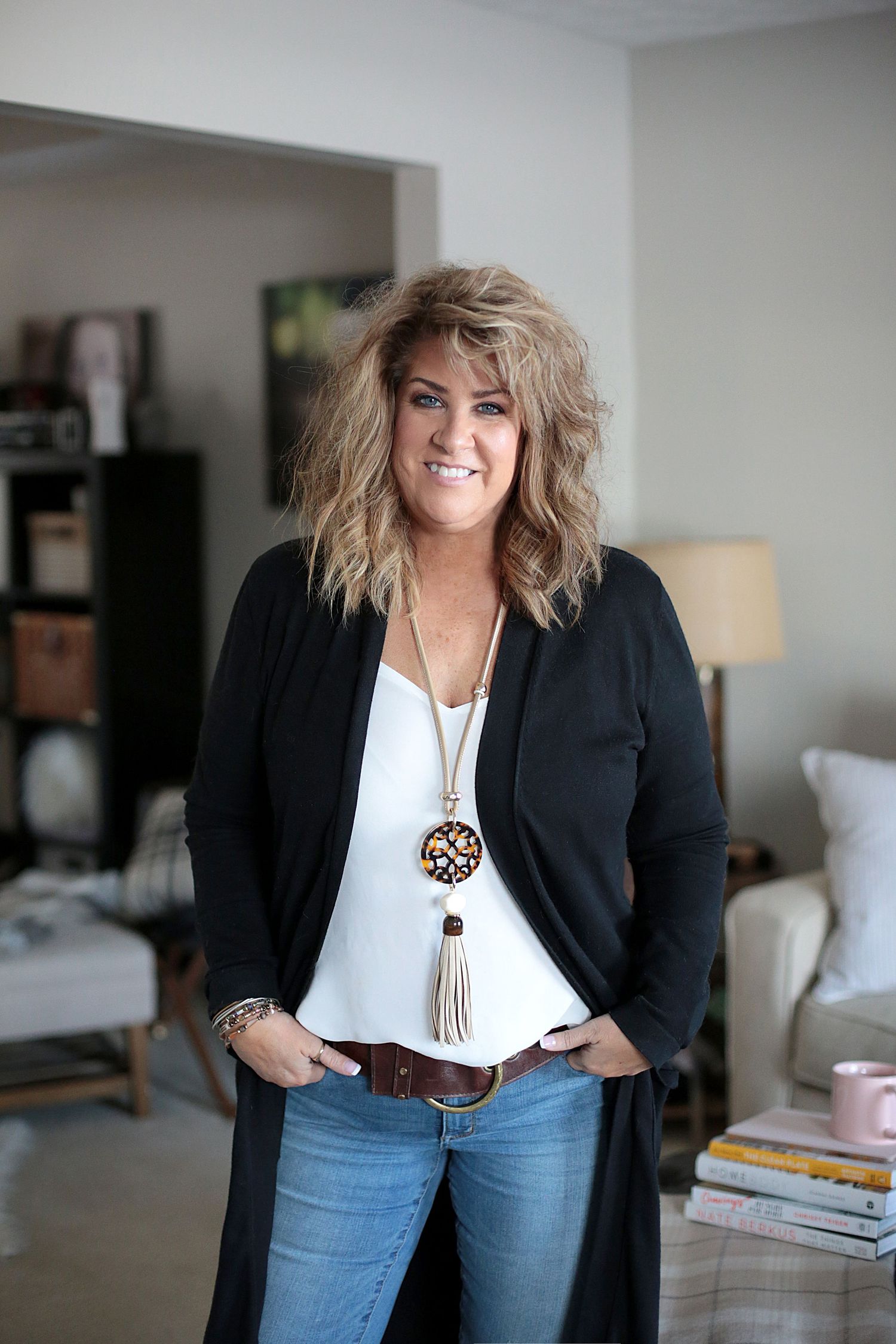A casual yet stylish portrait of someone wearing a long black cardigan and statement necklace.