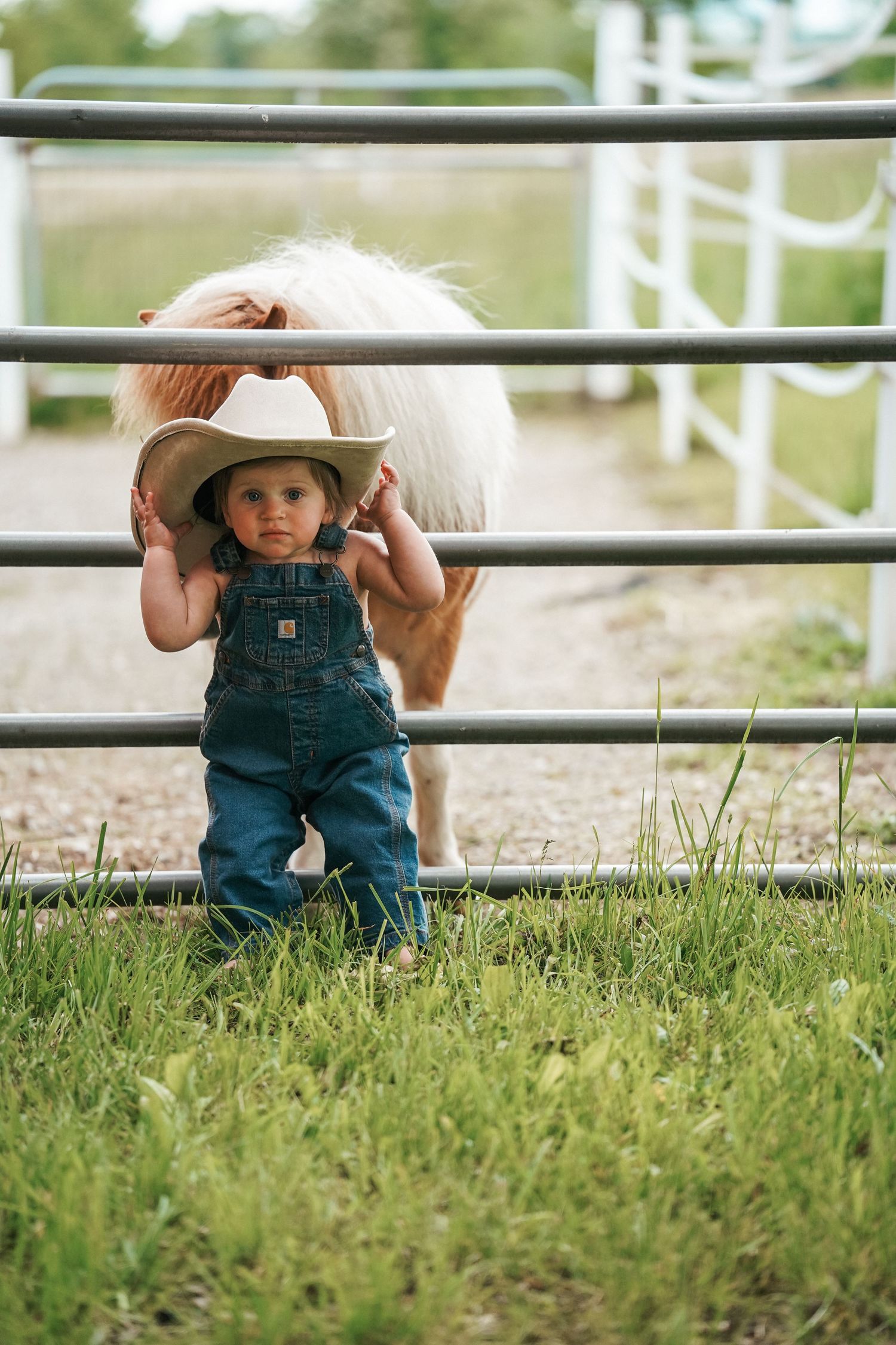 A row of three cropped images showing small boots and overalls on grassy ground near white fence posts.