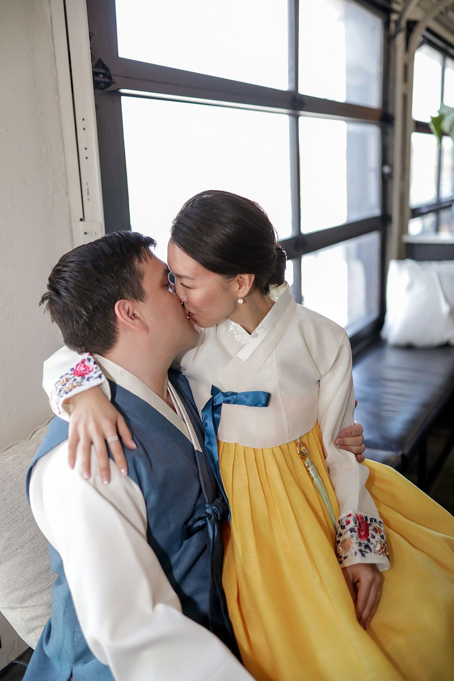 A couple in a cream and yellow dress and navy suit share intimate moments across four progressive candid shots.