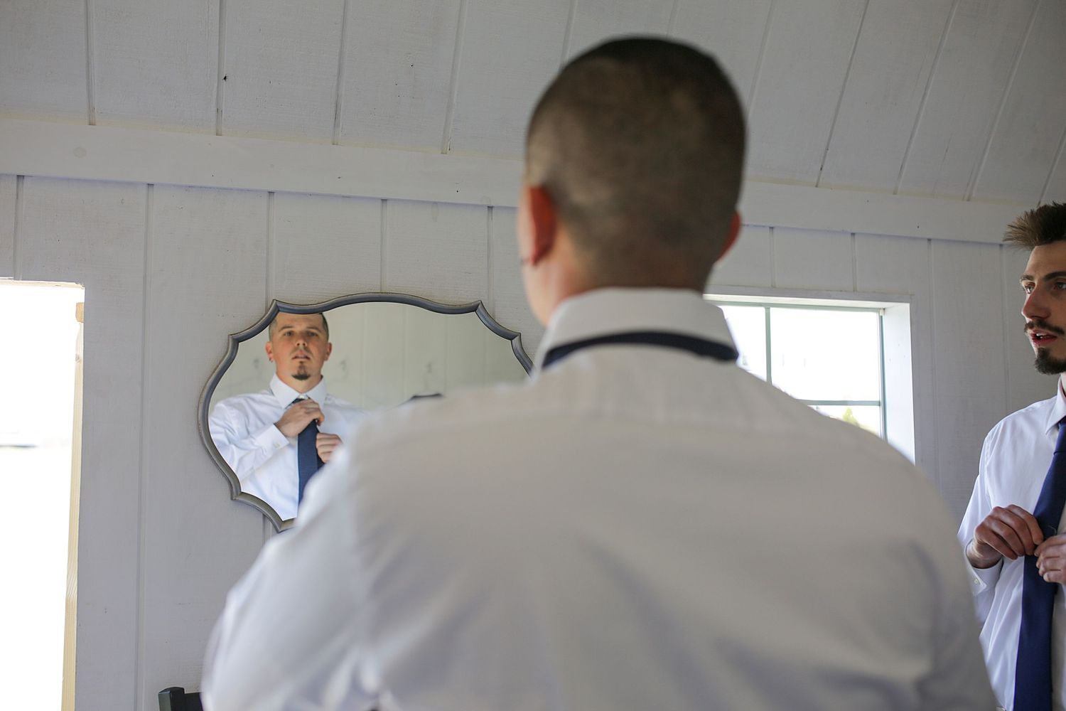 Business colleagues in a modern office meeting room discuss ideas while standing around a conference table.