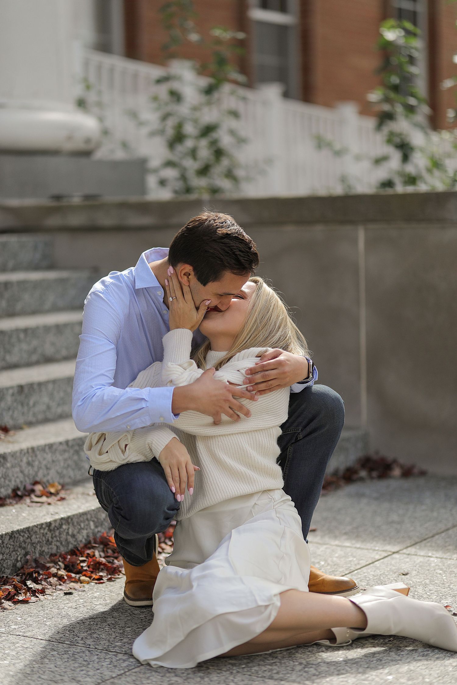 Intimate couple sharing tender moments together on outdoor stone steps in autumn.