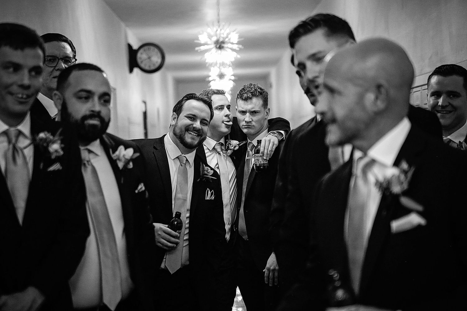 A group of formally dressed guests gather in conversation at what appears to be a social or business event.