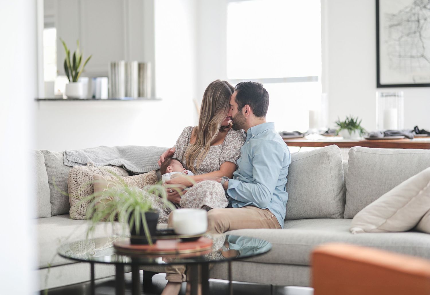 Cozy modern living room interior with gray sofa and natural light streaming through windows. Newborn photographer Chagrin Falls, Ohio.