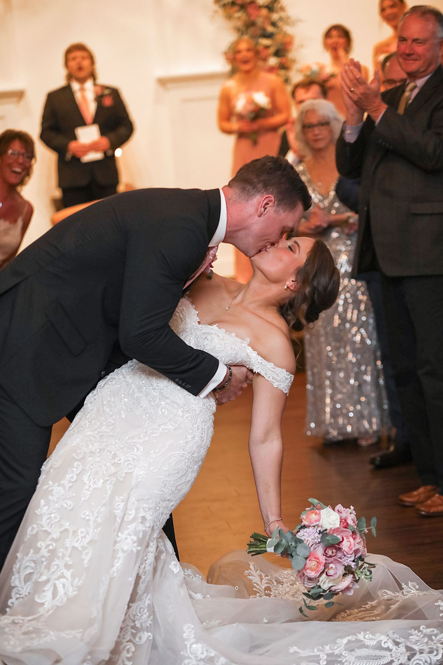 A romantic wedding dance dip sequence showing a couple in white dress and suit on the dance floor.