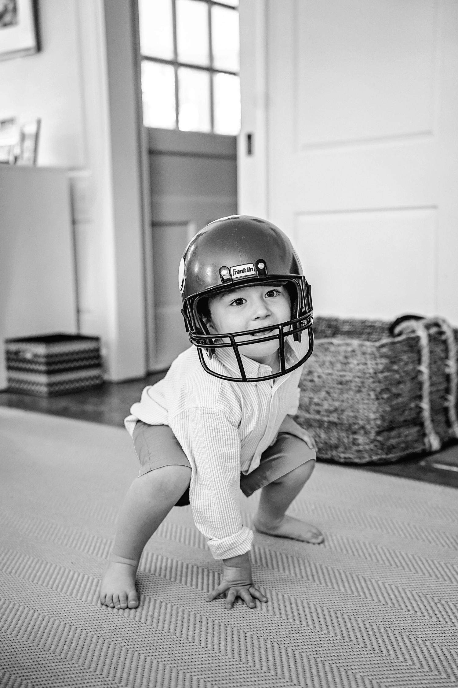 Black and white sequence showing crawling baby wearing headphones while exploring a carpeted floor in natural light.