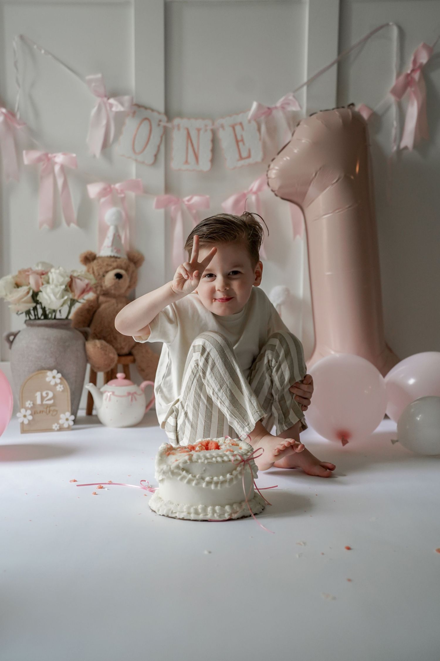 Collage of first birthday cake smash photos with pink decorations, teddy bears and balloons against white backdrop.