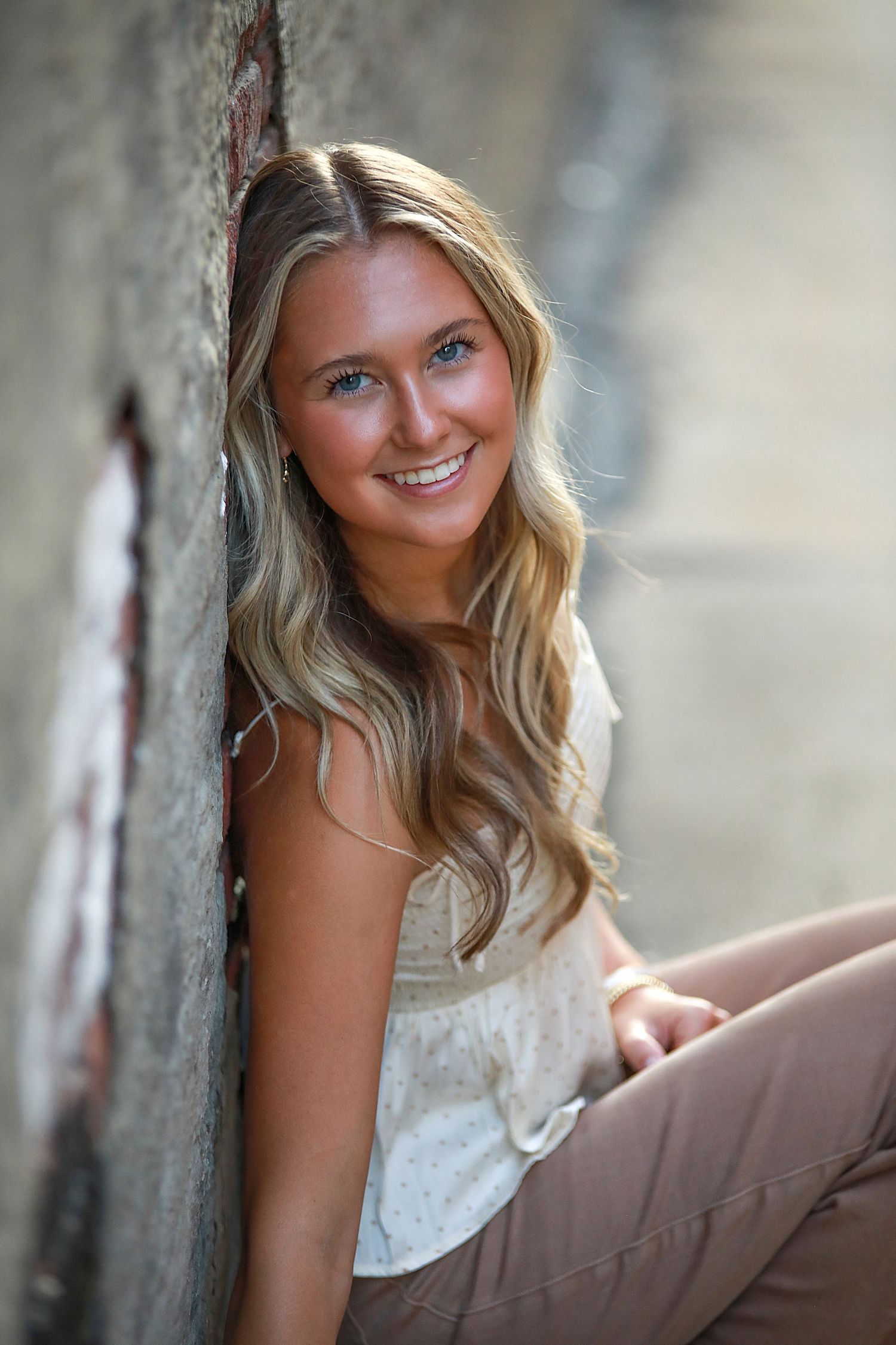 Natural light portrait session against textured wall background with soft bokeh effect. Senior portraits in Medina, Ohio