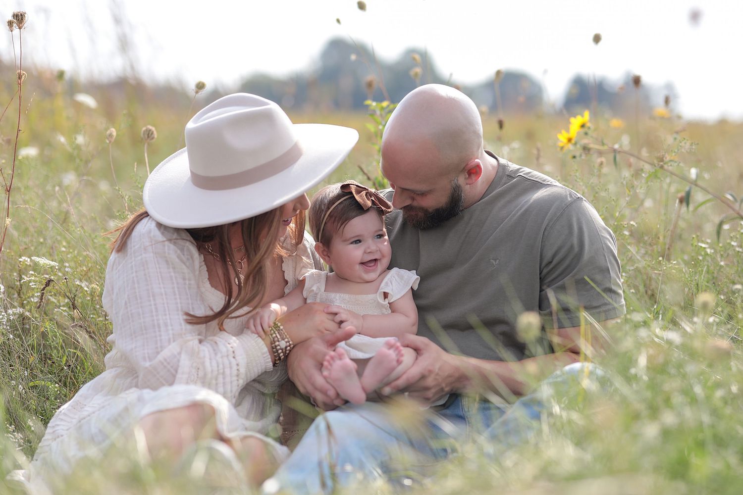 Family sitting together in wildflower meadow during golden hour.  Family Photography in Medina Ohio
