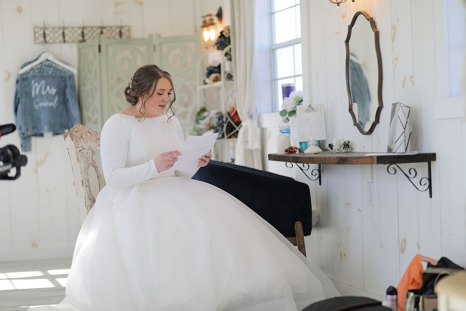 A room with multiple mirrors hanging on white walls reflects sunlight creating an ethereal atmosphere.