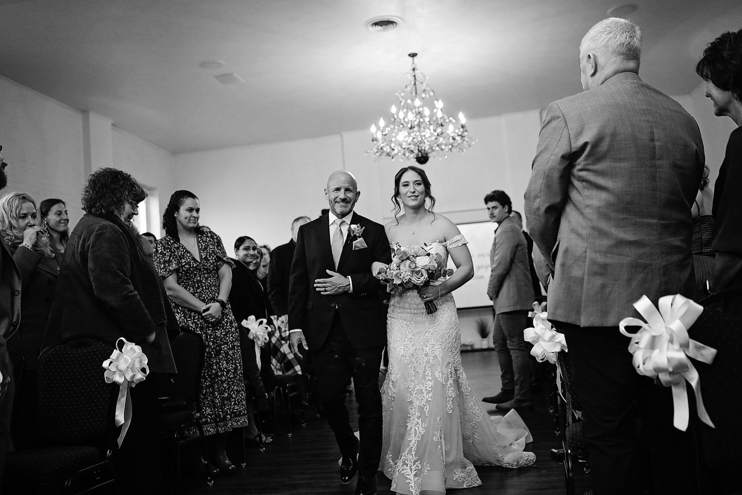 Wedding guests dancing together on the dance floor at an indoor reception celebration.