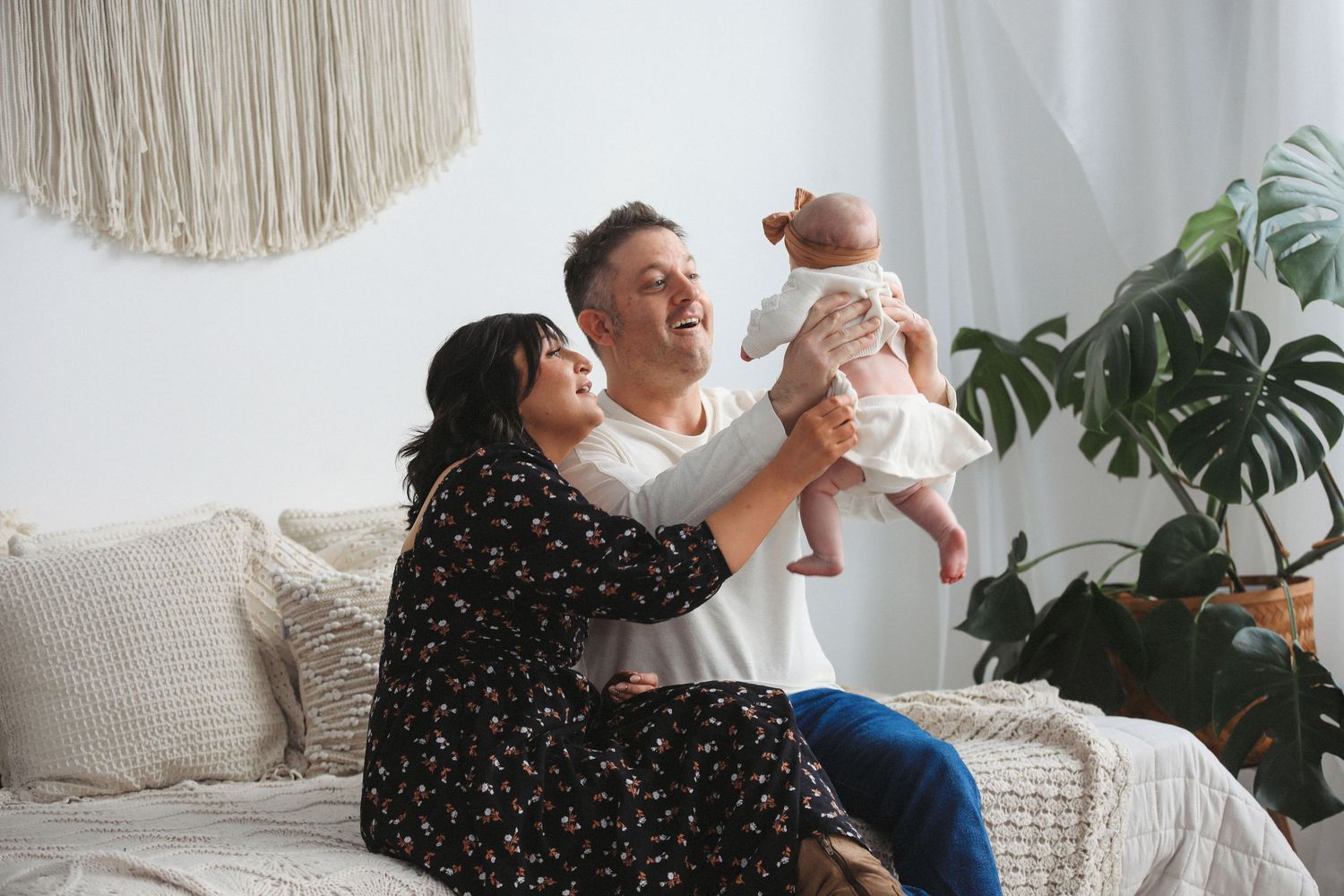 Parent and baby share joyful moments together while playing in a bright, modern living room setting.