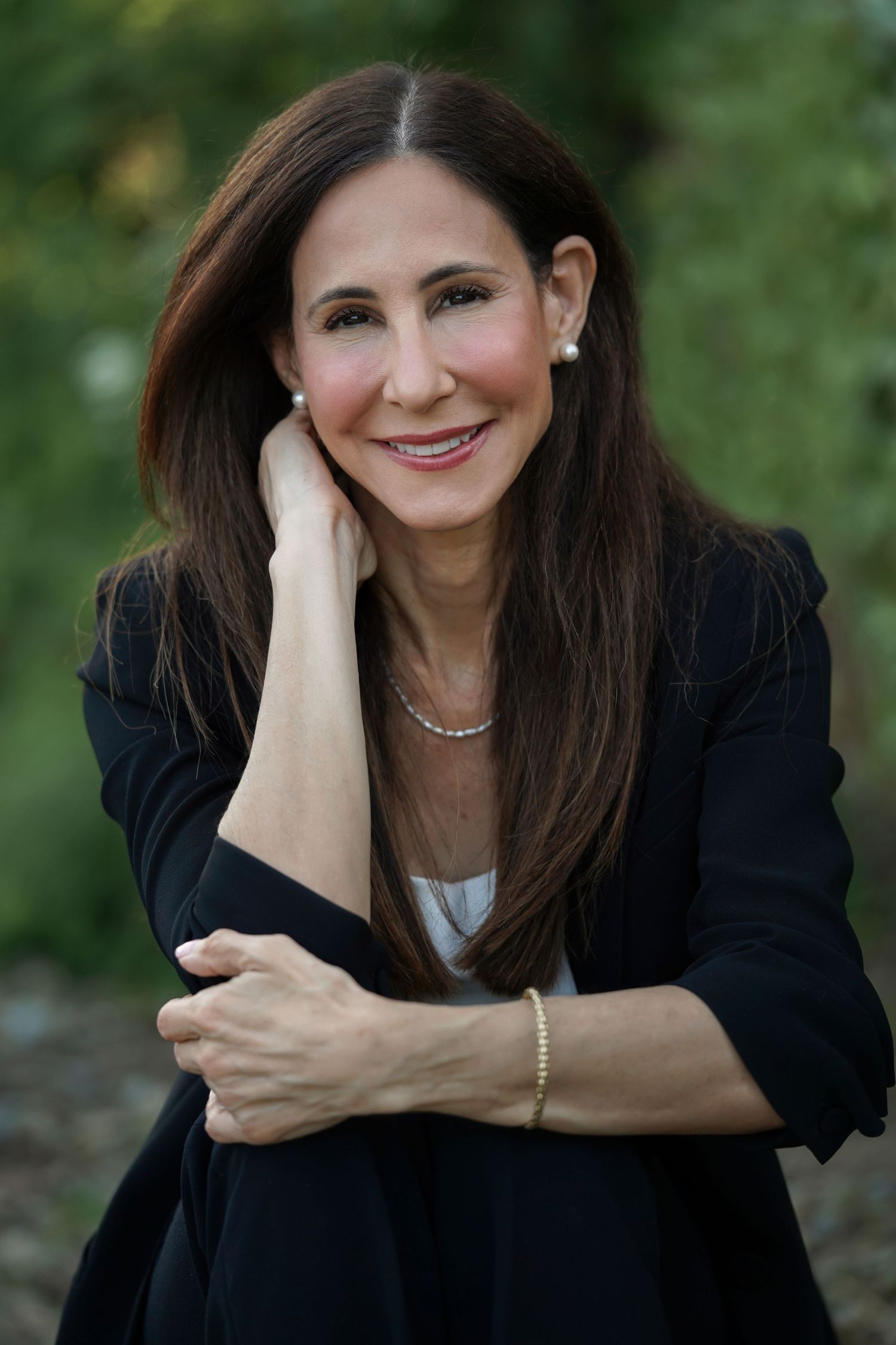 A person poses outdoors in a black top against a natural background in a five-photo collage series.
