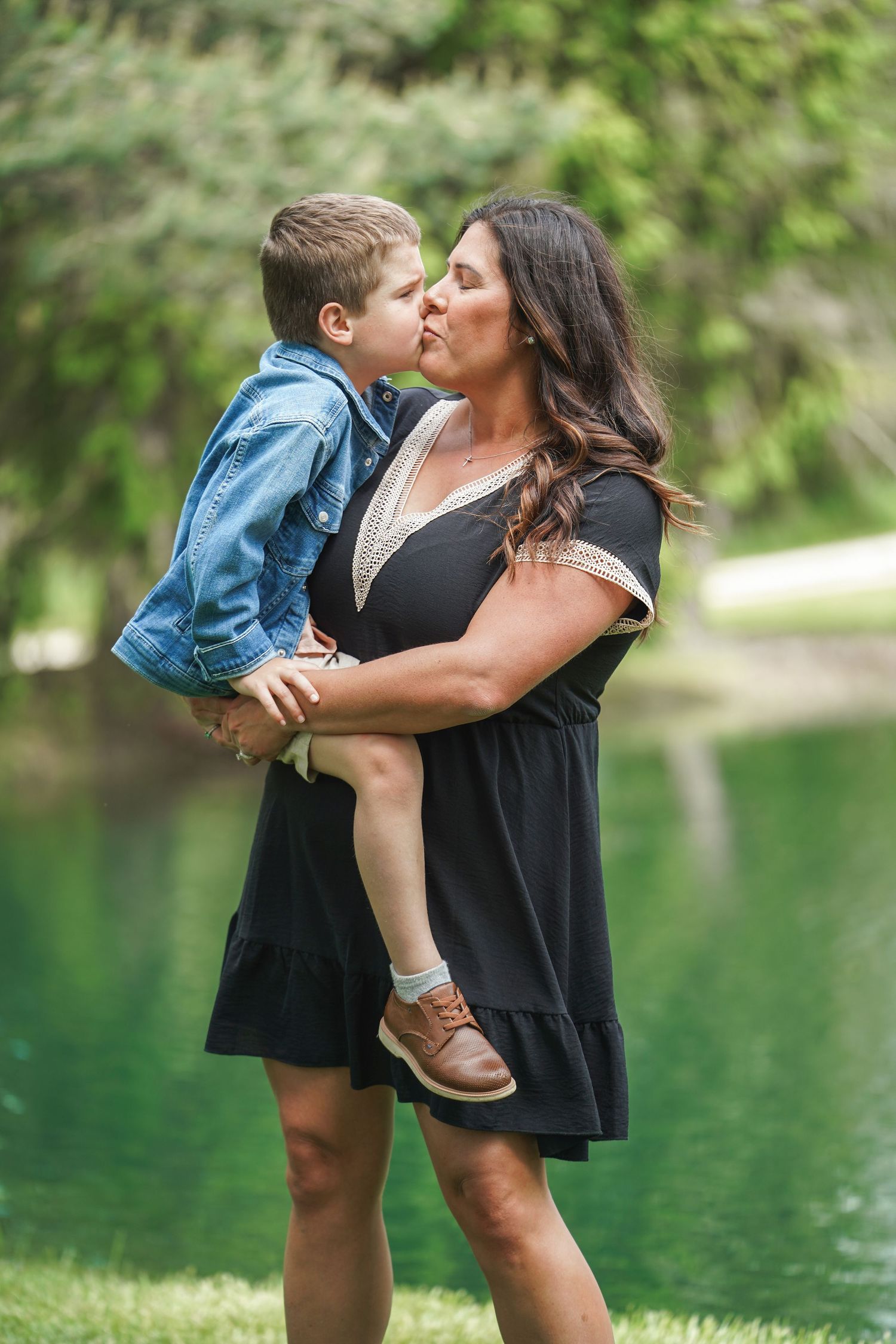 A series of tender moments captured by a lake with a green forested backdrop.