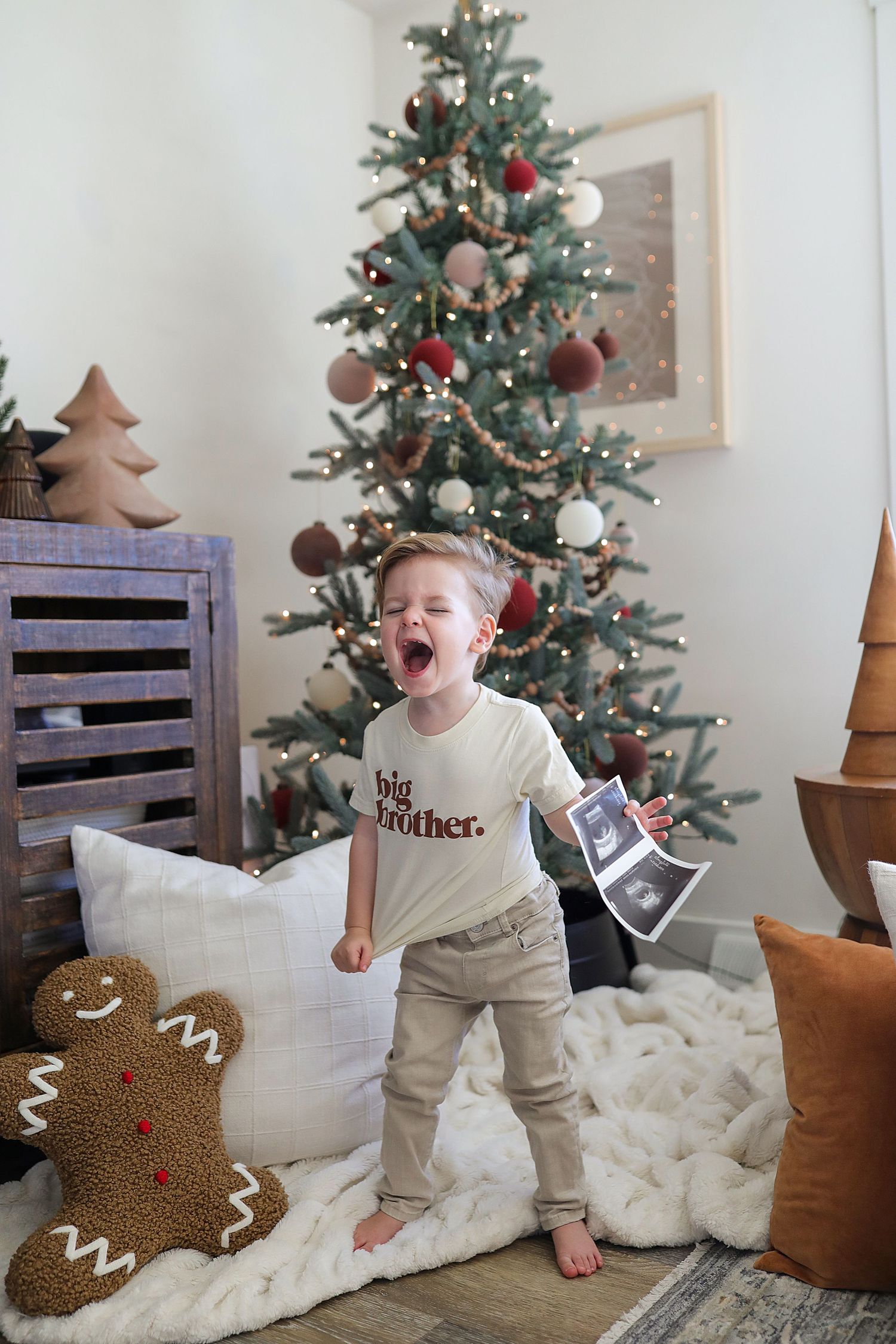 A series of Christmas photos showing a toddler playing with a decorative gingerbread pillow near a decorated tree.