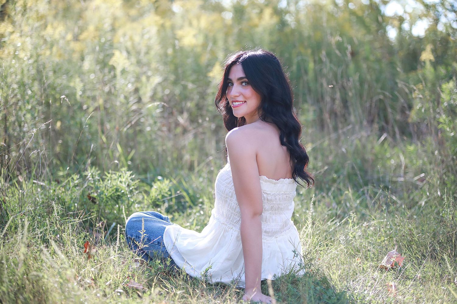 Senior Photography in Brunswick, Ohio outdoor. A portrait in white dress sitting in tall grass during golden hour.