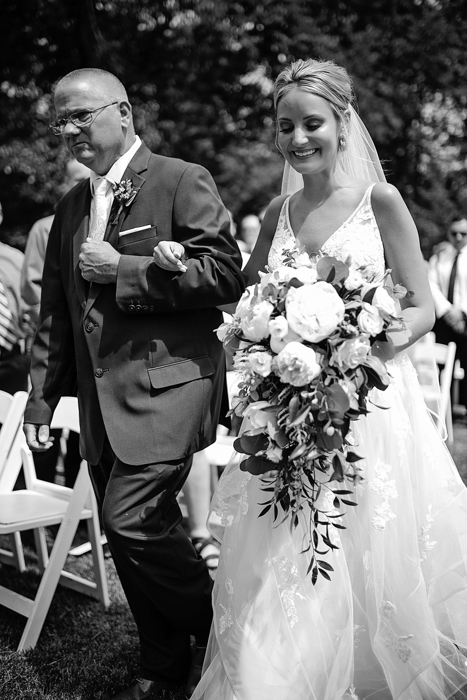 Black and white wedding photos showing joyful moments with the bridal party outdoors.