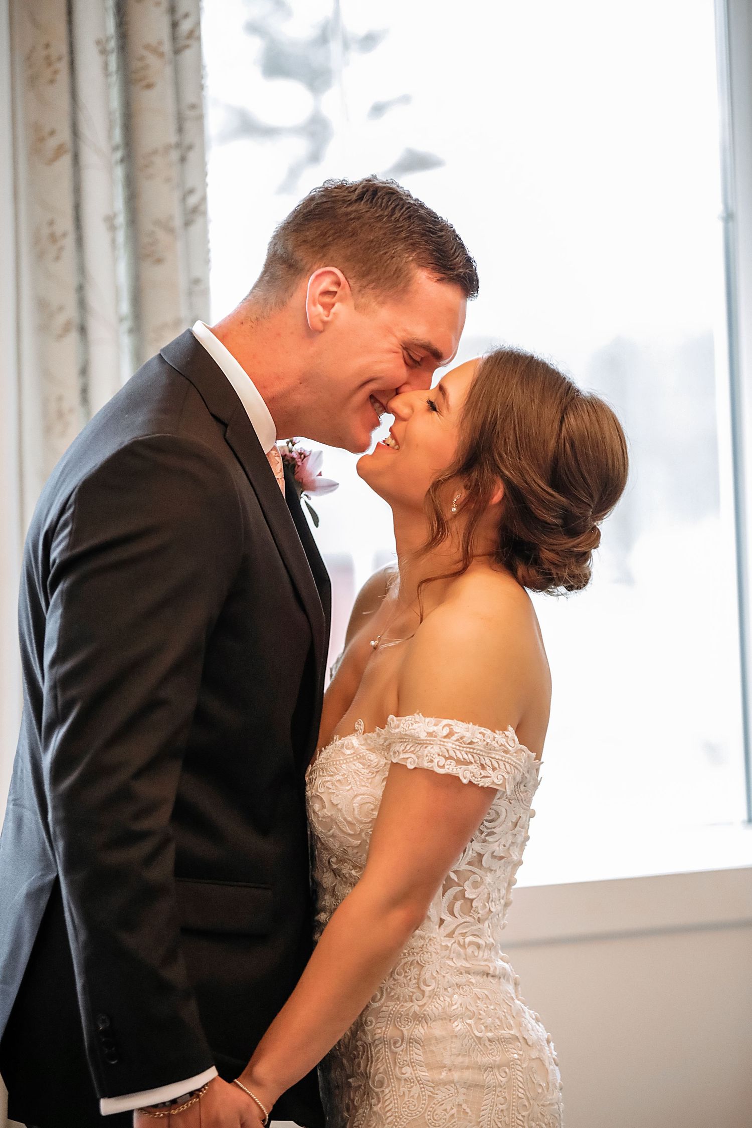 A romantic wedding kiss sequence showing three progressive shots of a couple in formal attire by bright windows.